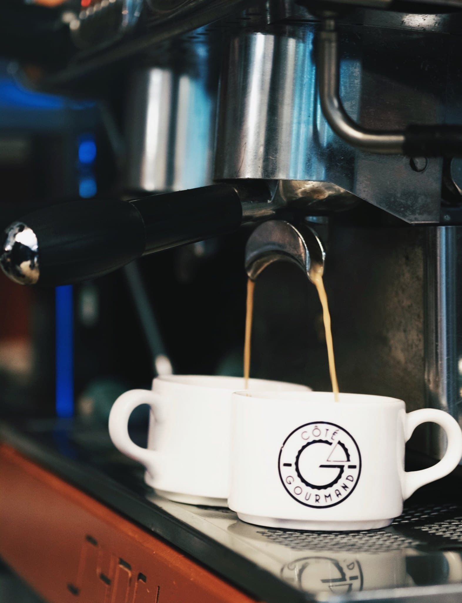 Deux cafés qui coulent dans les tasses Côté Gourmand